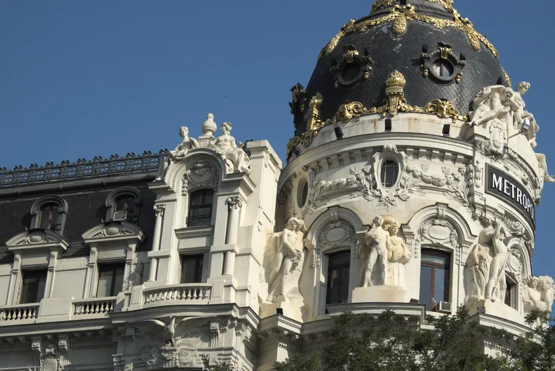 Dome of the Metrópolis building on Calle de Alcalá, Madrid, against a blue sky.